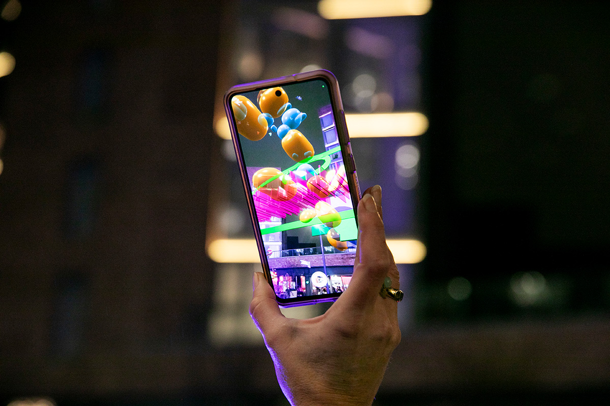 A visitor interacts with a piece of the Hexahedron Exhibition  by Imvizar & Maser (2024) outside of the gallery building, that followed  the initial exhibit at RHA Gallery in 2023. Photo: Imvizar. © Imvizar.